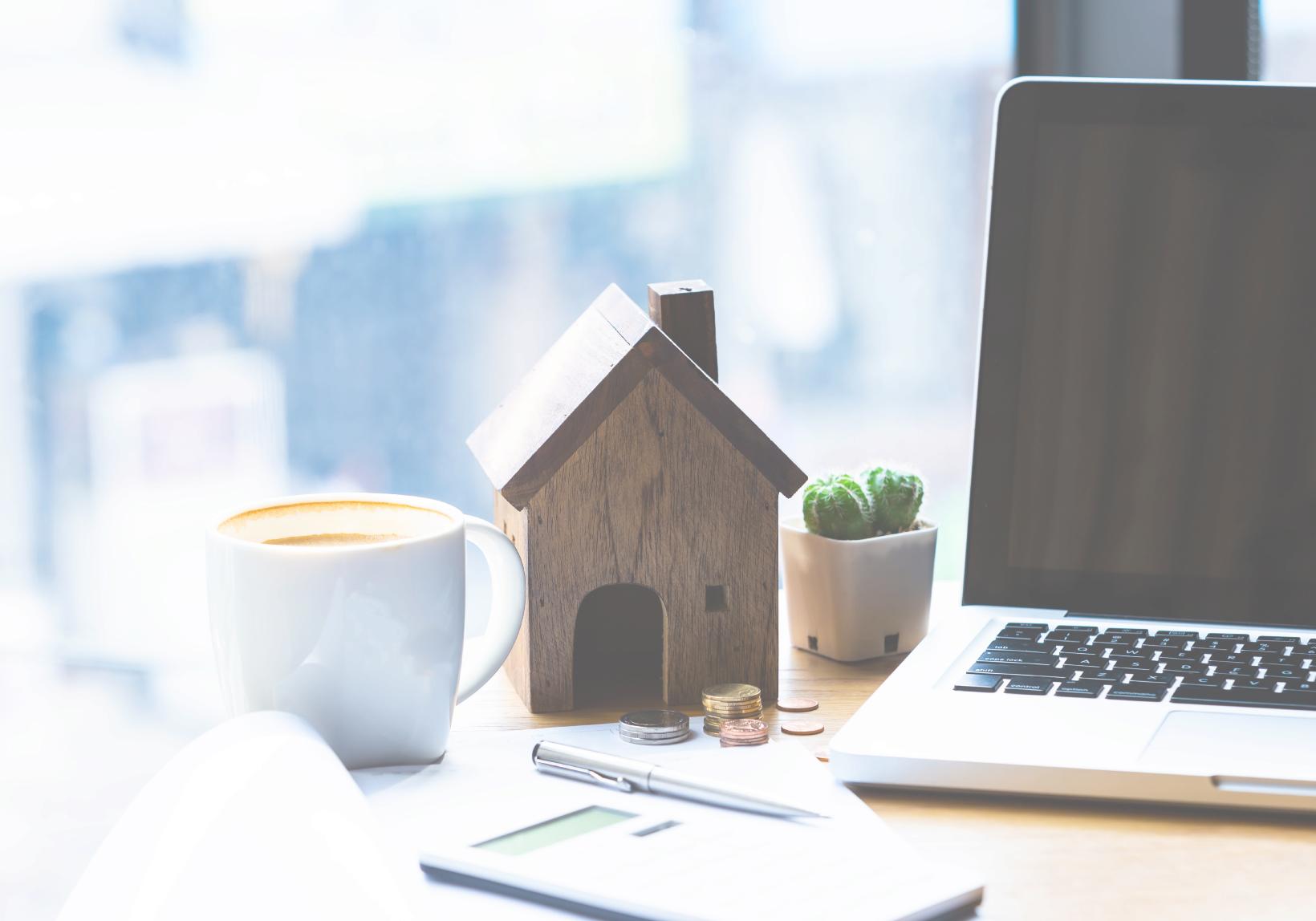 coffee wooden house calculator pen laptop on desk